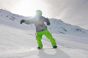 jovem feliz se divertir no inverno no pico da montanha foto