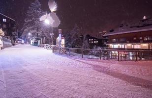 ruas nevadas da aldeia de montanha alpina foto