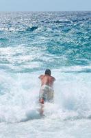 homem pulando no mar foto
