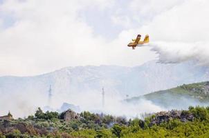 avião jogando água em chamas foto