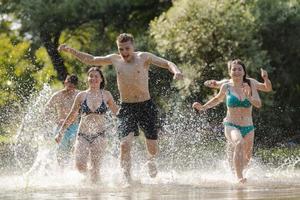 grupo de amigos felizes se divertindo no rio foto