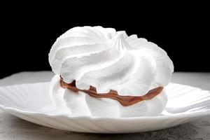 dois merengues brancos como a neve em um prato branco. lindo bolo branco. foto