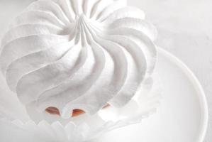 merengues brancos de baunilha em um prato branco. foto