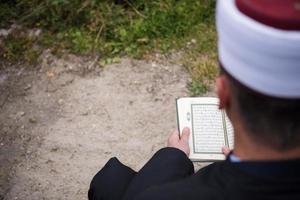 leitura do livro sagrado do Alcorão pelo imã no funeral islâmico foto