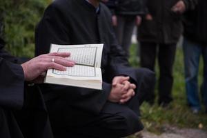 leitura do livro sagrado do Alcorão pelo imã no funeral islâmico foto