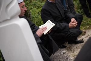 leitura do livro sagrado do Alcorão pelo imã no funeral islâmico foto