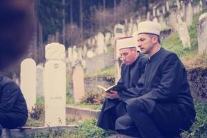 leitura do livro sagrado do Alcorão pelo imã no funeral islâmico foto