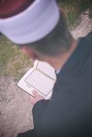 leitura do livro sagrado do Alcorão pelo imã no funeral islâmico foto