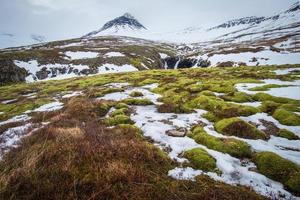 a bela paisagem da montanha nevada em stodvarfjordur do leste da islândia coberta por névoa na temporada de inverno. foto