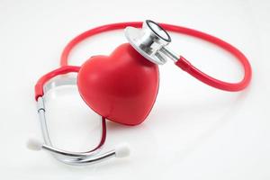 estetoscópio e coração vermelho sobre fundo branco foto