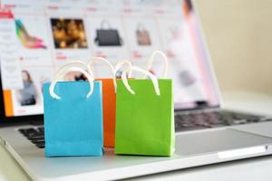 conceito de serviço de entrega de compras on-line ou comércio eletrônico, sacola de papel em um computador portátil, conceito on-line de compras fáceis foto
