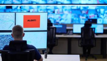 jovem operador masculino trabalhando em uma sala de controle do sistema de dados de segurança foto