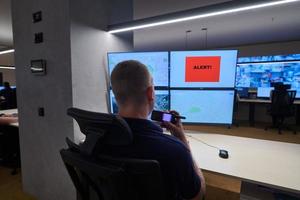 jovem operador masculino trabalhando em uma sala de controle do sistema de dados de segurança foto