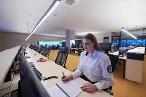 operador feminino trabalhando em uma sala de controle do sistema de dados de segurança foto