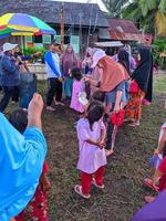 a emoção de adultos e crianças participando de uma competição de comer biscoitos para animar o dia da independência da república da indonésia, kalimantan oriental, indonésia 13 de agosto de 2022 foto