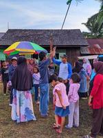 a emoção de adultos e crianças participando de uma competição de comer biscoitos para animar o dia da independência da república da indonésia, kalimantan oriental, indonésia 13 de agosto de 2022 foto