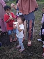 a emoção de adultos e crianças participando de uma competição de comer biscoitos para animar o dia da independência da república da indonésia, kalimantan oriental, indonésia 13 de agosto de 2022 foto