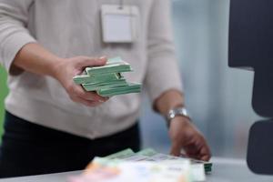 funcionários do banco classificando e contando notas de papel foto