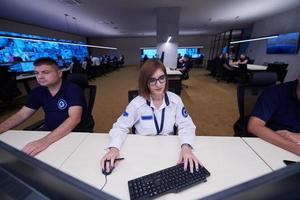 operador feminino trabalhando em uma sala de controle do sistema de dados de segurança foto