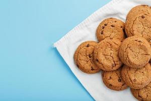 um monte de biscoitos de aveia com chocolate em um guardanapo em um fundo azul foto