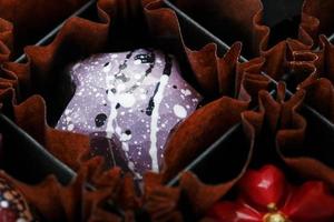 requintado doce de chocolate artesanal é pintado com padrões de estrelas da galáxia close-up foto