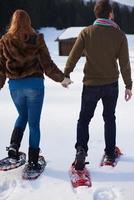 casal se divertindo e andando com sapatos de neve foto