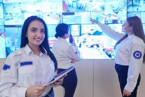 seguranças femininas trabalhando em uma sala de controle do sistema de dados de segurança foto