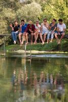 amigos desfrutando de melancia enquanto está sentado na ponte de madeira foto