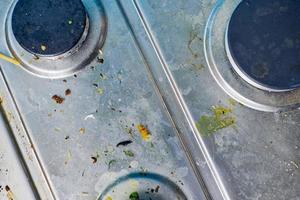 fogão sujo com respingos de óleo, manchas de gordura e restos de comida foto