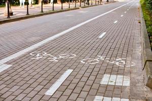 ciclovia em dois sentidos, marcando ciclovia na calçada, placa de bicicleta pintada de branco na estrada, símbolo de ciclo foto