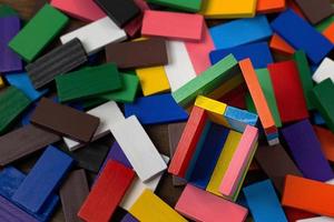 a casa de construção multicolor do domino na imagem da mesa de madeira. foto