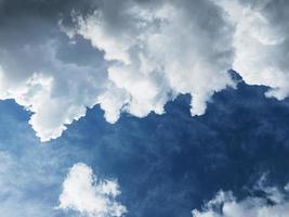 nuvens cumulus diagonalmente contra um céu azul escuro foto