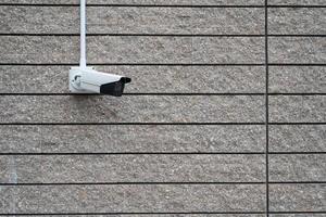 câmera de segurança no edifício moderno escuro, conceito de tecnologia. câmera de cctv na parede de concreto foto