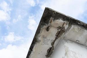 telhado de teto danificado pela água em uma casa velha. interior do edifício de danos causados pela água. casa do teto quebrada. rachadura de concreto do teto e expôs a estrutura da barra de aço enferrujada. foto