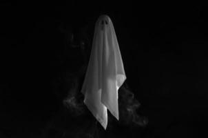 foco parcial da folha fantasma branca voando em fundo escuro com fumaça. conceito assustador de halloween. foto