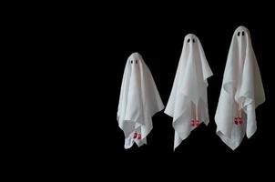 um grupo de fantasia de lençol branco fantasma feminino voando no ar com fundo preto. conceito assustador mínimo de halloween. foto