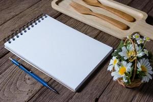 caderno aberto com bandeja de madeira na mesa foto