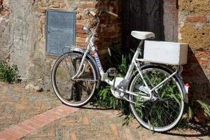 pienza, toscana, itália - 19 de maio bicicleta branca encostada em uma parede em pienza toscana itália em 19 de maio de 2013 foto