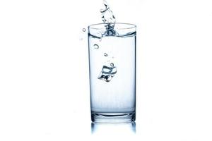 copo de água com cubo de gelo no fundo branco. foto