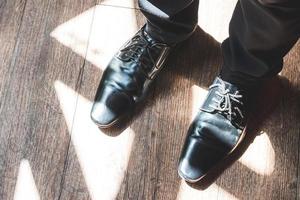 close-up de pernas de homem em sapatos elegantes com atacadores. conceito de moda e calçados foto
