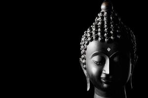 estátua de Buda em fundo preto. espaço livre para texto foto