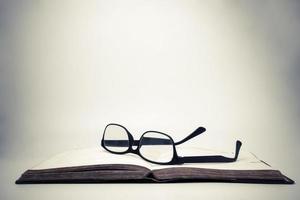 óculos em um livro aberto com fundo vintage. foto