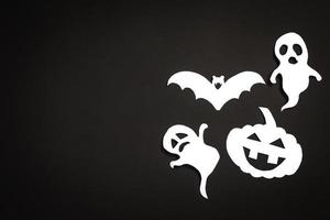 fundo de férias de halloween com abóbora, fantasmas e morcego cortar papel em fundo preto. espaço livre para texto. foto