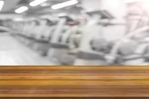 plataforma de espaço de tábua de madeira vazia com fundo de equipamento de ginástica de fitness desfocado foto