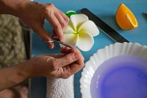 manicure em casa. mulher cortando as unhas com uma tesoura de unha. cuidados com as unhas. foto