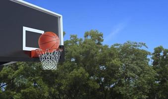 bola de basquete e cesta de basquete em fundo branco. acertar a bola na cesta foto