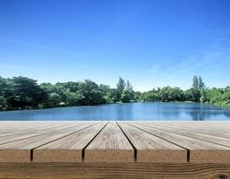 terraço de mesa de madeira com uma atmosfera refrescante pela manhã, pequeno lago de pântano no verão foto