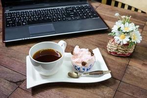 café com bolo no vapor e equipamento de escritório na área de trabalho foto