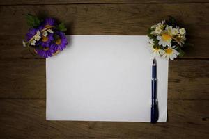 uma folha de papel com uma caneta na mesa de escritório de madeira foto