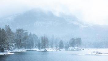 esta foto foi tirada depois que uma tempestade de neve deixou cair uma bela neve sobre um lago na floresta nacional de tahoe, no norte da califórnia.